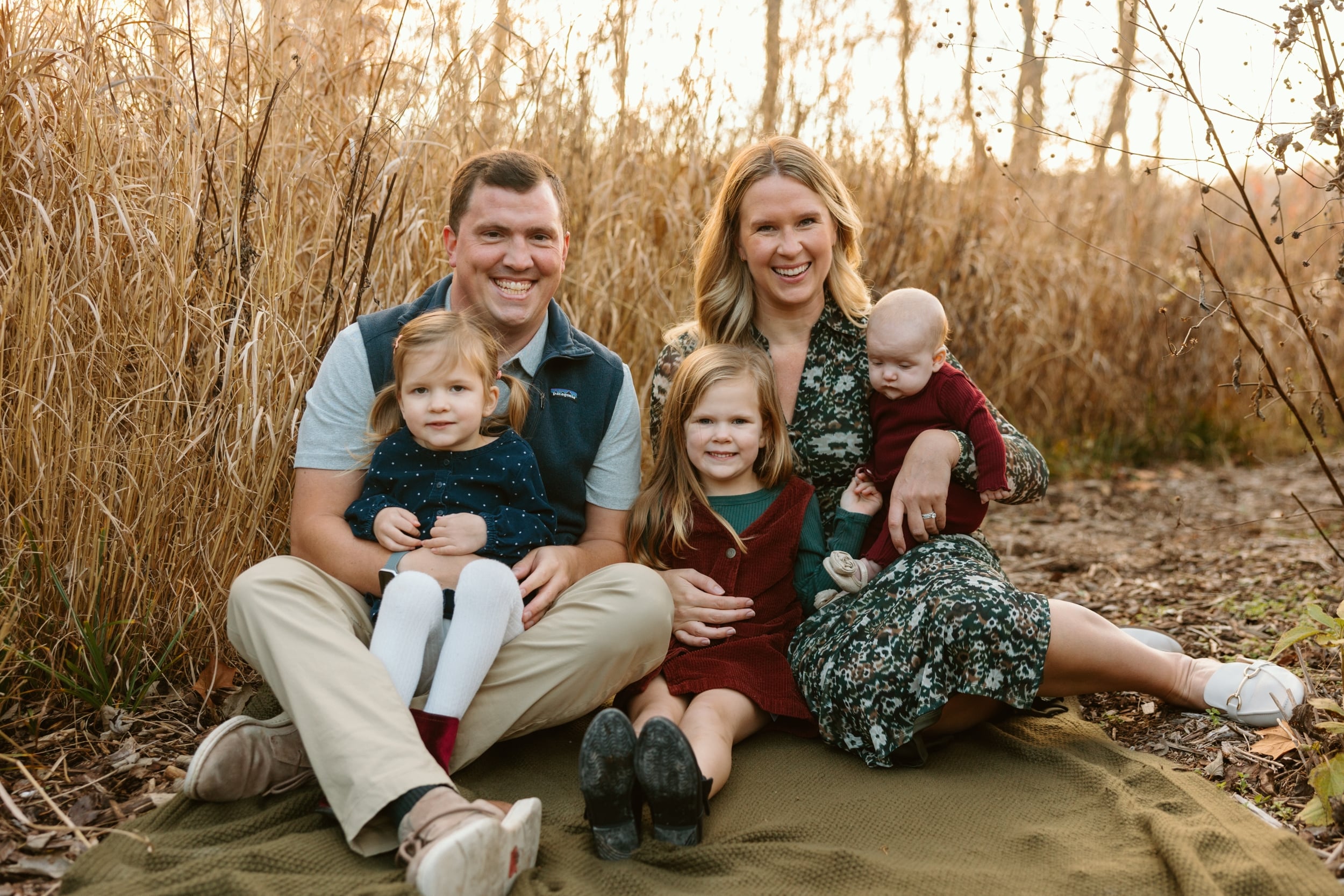 Molly Lee posing in a field with her partner and three children